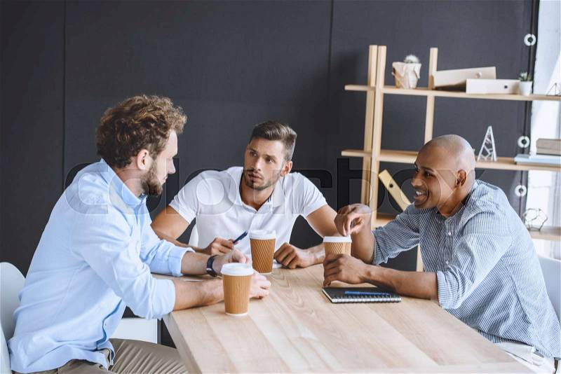 Multicultural business people discussing business plan at meeting in office, stock photo