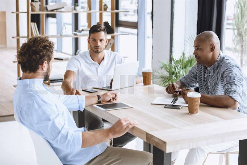 Multiethnic business people discussing business idea at meeting in office, stock photo