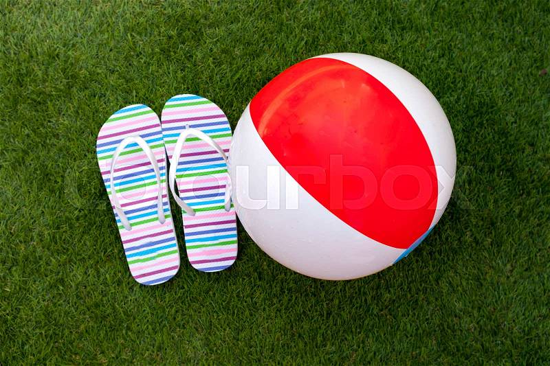 Flip-flops on the green grass of the pool, stock photo