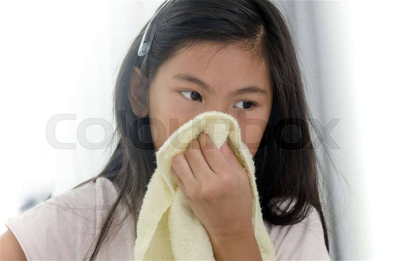 Asian sick girl using handkerchief at home, stock photo