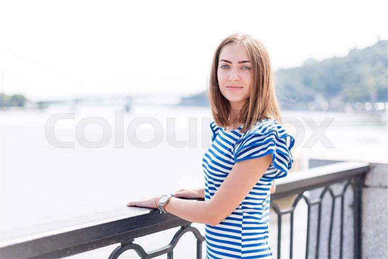 Pretty young woman enjoying sun and good warm day near the river, summer vacation, woman relaxing outdoors, stock photo