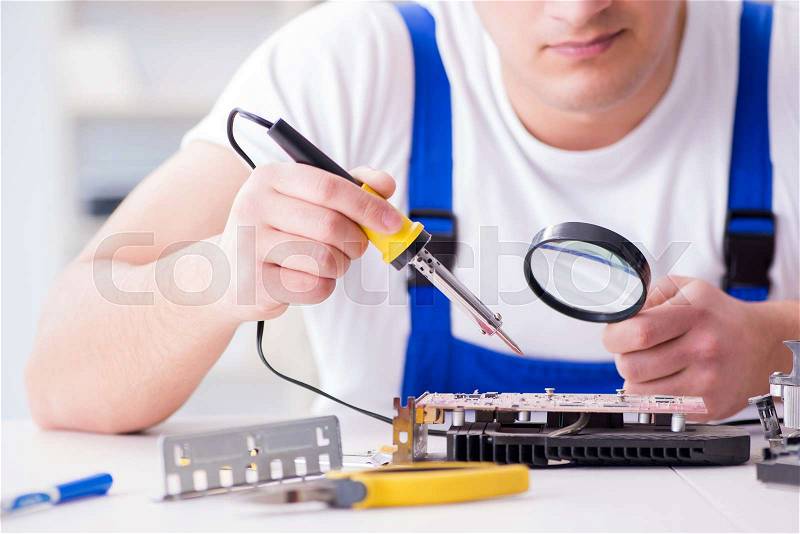 Computer repairman repairing desktop computer, stock photo