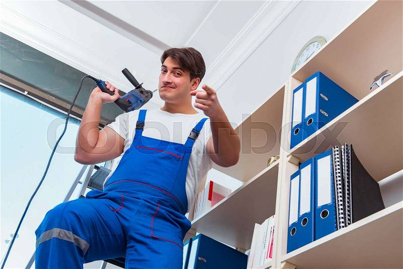 Young worker repairing shelves in office, stock photo