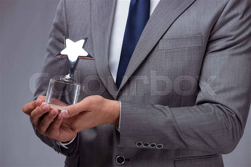 Businessman holding star award in business concept, stock photo
