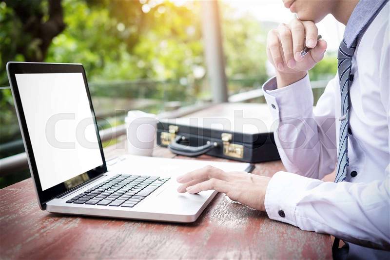 Businessman using modern laptop for working at personal space outdoor, wireless connection internet on his notebook computer, stock photo