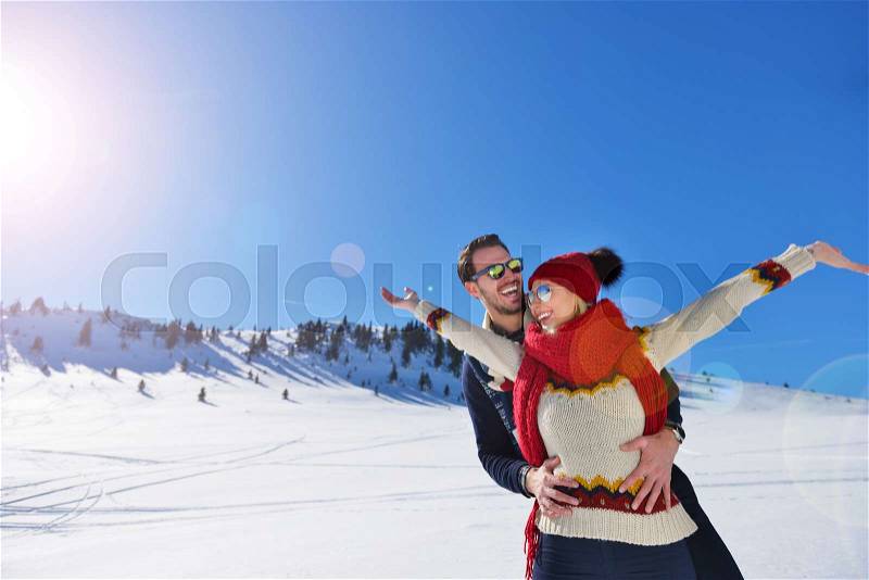 Happy couple playful together during winter holidays vacation outside in snow park, stock photo