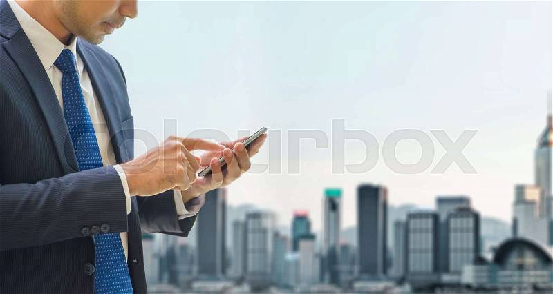 Business man use mobile phone at top of office building see view of cityscape blur background, stock photo