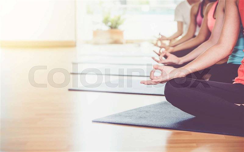 Close up hands of yoga group sit and meditates in a training studio fitness room, Calm and relax concept,wellness and healthy lifestyle, stock photo