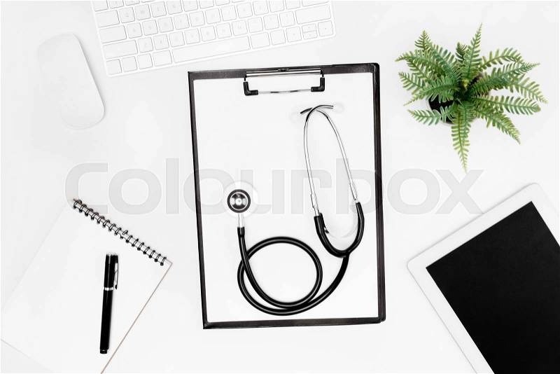 Flat lay with stethoscope, clipboard, empty notebook and digital devices isolated on white, stock photo