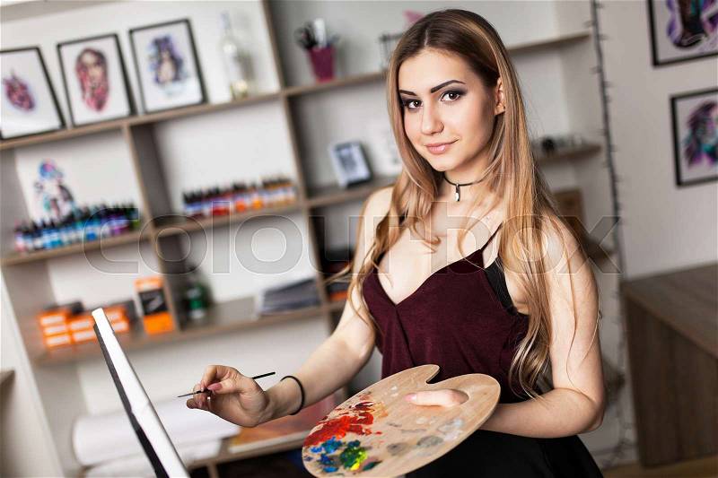 Artist painting in her workshop, stock photo