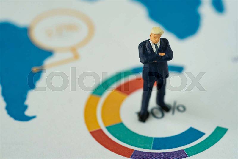 Miniature people business concept as small figure businessmen standing on analysis graph chart, stock photo