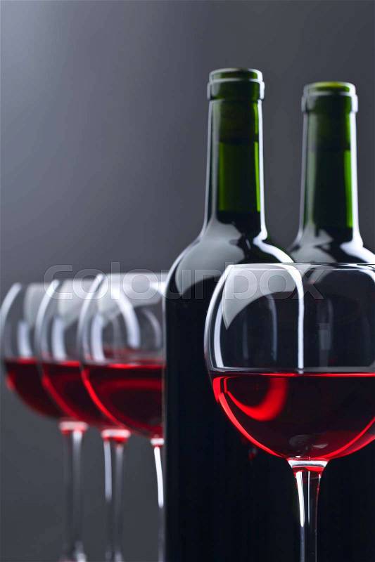 Bottles and glasses of red wine on a dark background , stock photo