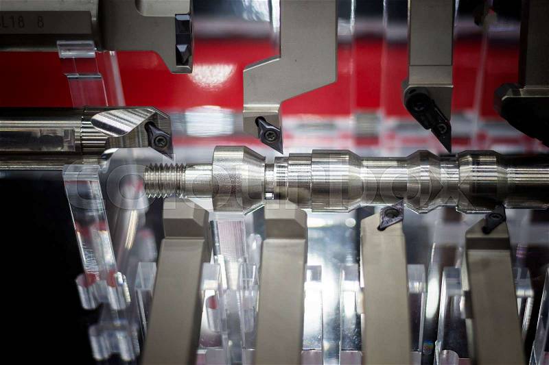 Steel workpiece in fixture demonstrate how to be cut by cutting tools ; focus at center cutting tool, stock photo