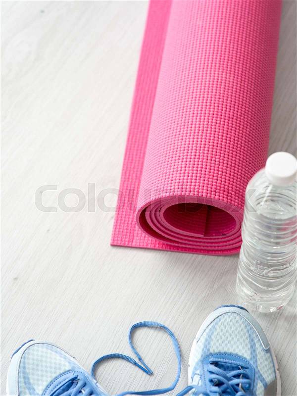 Heart shape Sport shoes, yoga mat, bottle of water on wooden background. Sport equipment. Concept healthy life. Selective focus, stock photo