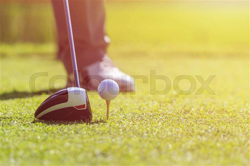 Golf player. A man playing golf in green course. Focus on golf ball, stock photo