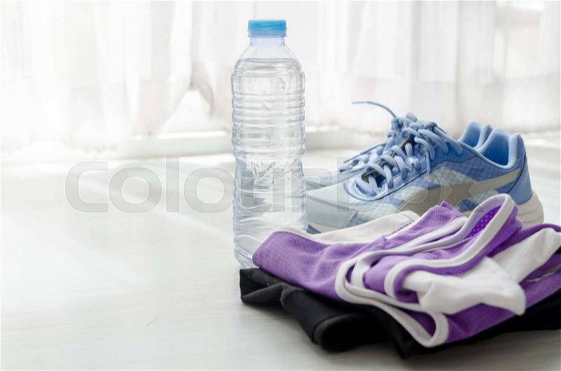 A bottle of water, sport shoes and sportwear with window light. Sport lifstyle concept, stock photo