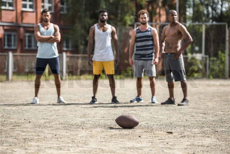 Group of young multicultural male football players on court, stock photo