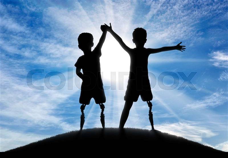 Children with disabilities. Two boys of a disabled person with a prosthetic leg standing, holding hands, on top of a hill, stock photo