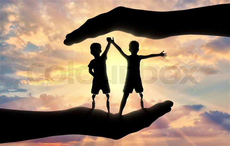 Help and care Children with disabilities. Two disabled boys with leg prostheses standing, in the hands of a man, stock photo