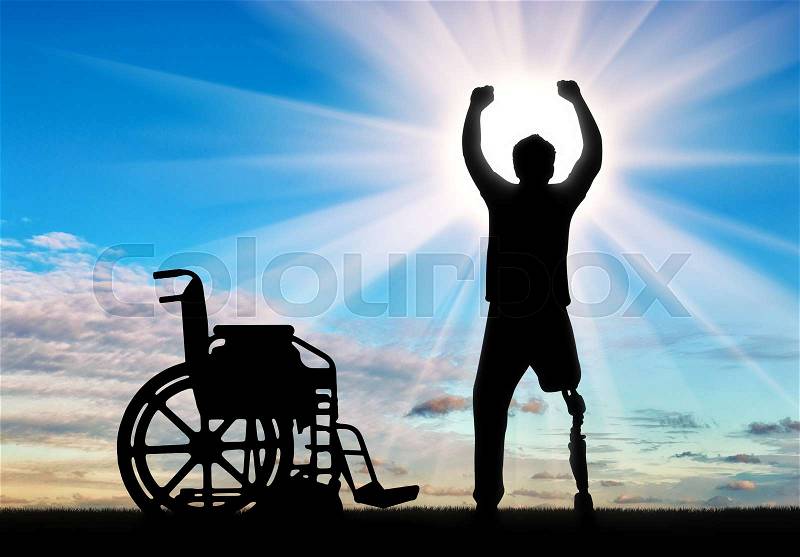 People with disabilities the concept. Happy disabled man with a prosthetic leg standing near a wheelchair at dawn, stock photo