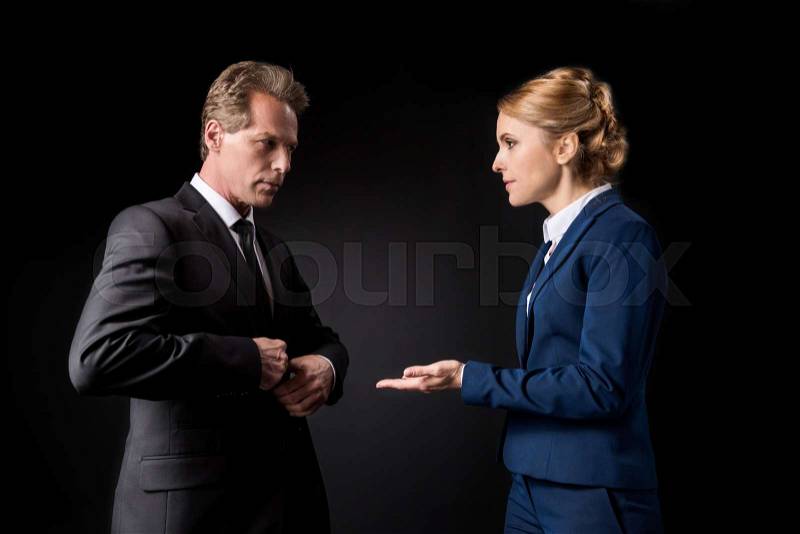 Middle aged business colleagues having conflict and quarreling isolated on black , stock photo