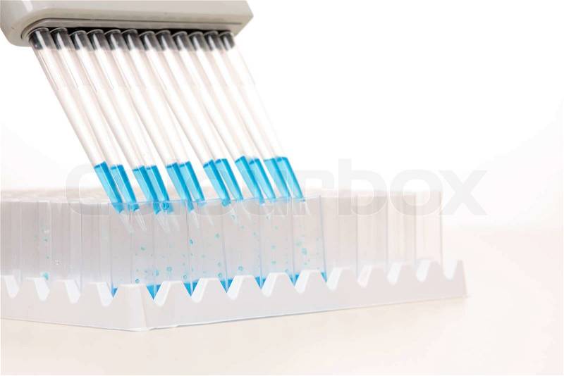Electronic pipettors can be programmed to aspirate, mix and dispense variable volumesWhen dispensing it is recommended the pipette be held at a 45 degree angleFocus to foreground shallow dof with copyspace, stock photo