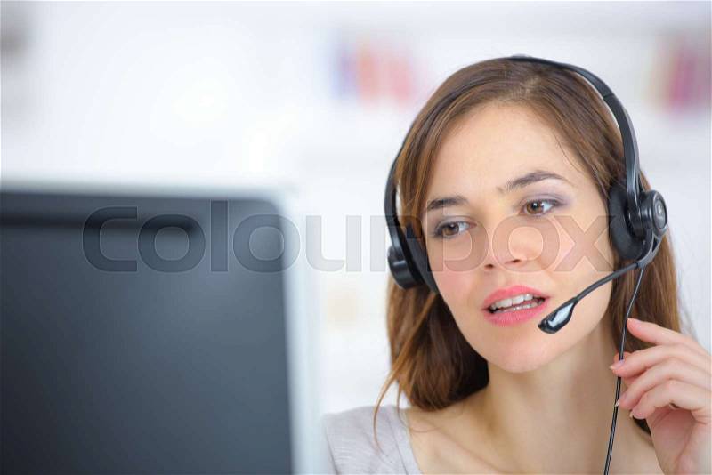 A young woman wearing an audio headset, stock photo