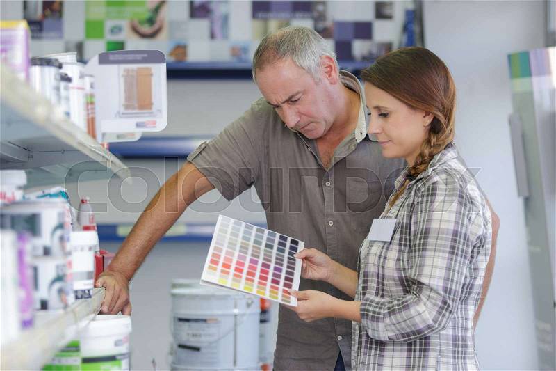 Daughter and dad hoosing wall paint colors, stock photo