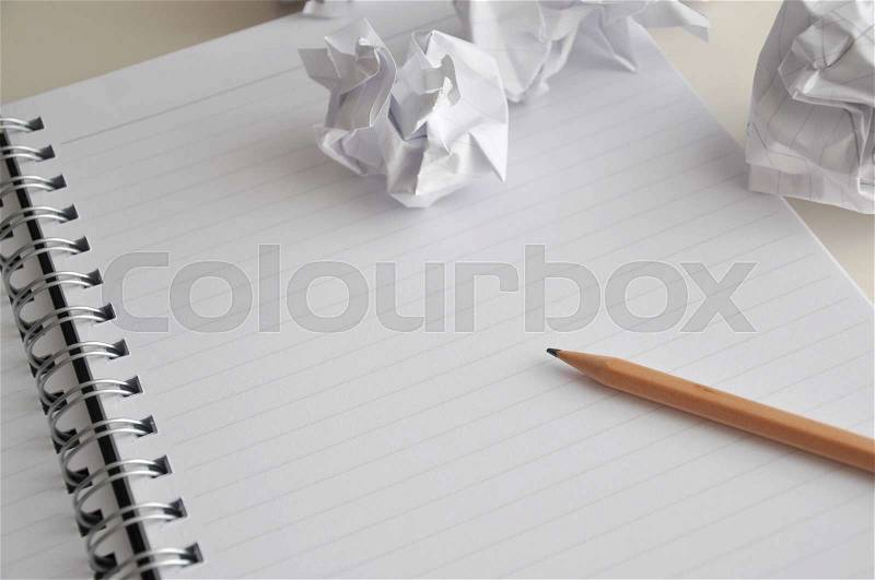 Blank page of notebook with pencil and crumpled paper on desk, stock photo