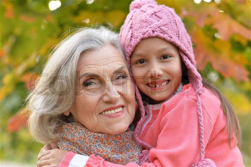 Happy grandmother and granddaughter in autumnal park, stock photo