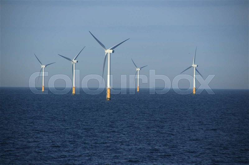 With the ferry along the wind farm in the North Sea between IJmuiden (The Netherlands) and Newcastle (Great Britain) at sunrise in the summer, stock photo