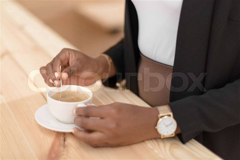 Cropped view of african american woman with coffee cup in cafe , stock photo