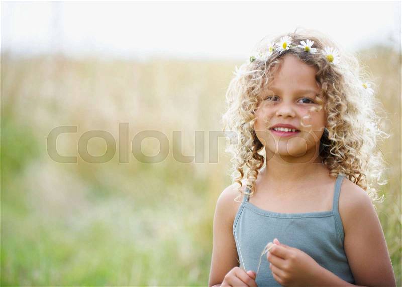 Young girl with daisies in hair, stock photo