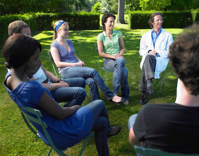 Circle of people sitting on chairs, stock photo