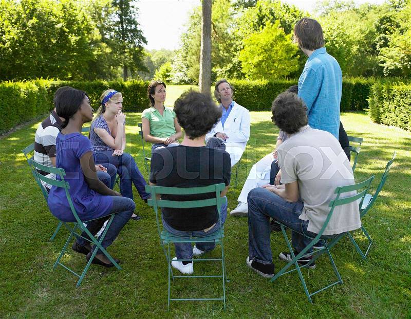 Circle of people in rehab, outdoors, stock photo