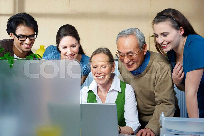 Group of people looking at laptop, stock photo