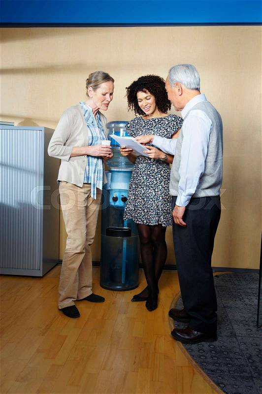 Casual meeting by office water cooler, stock photo