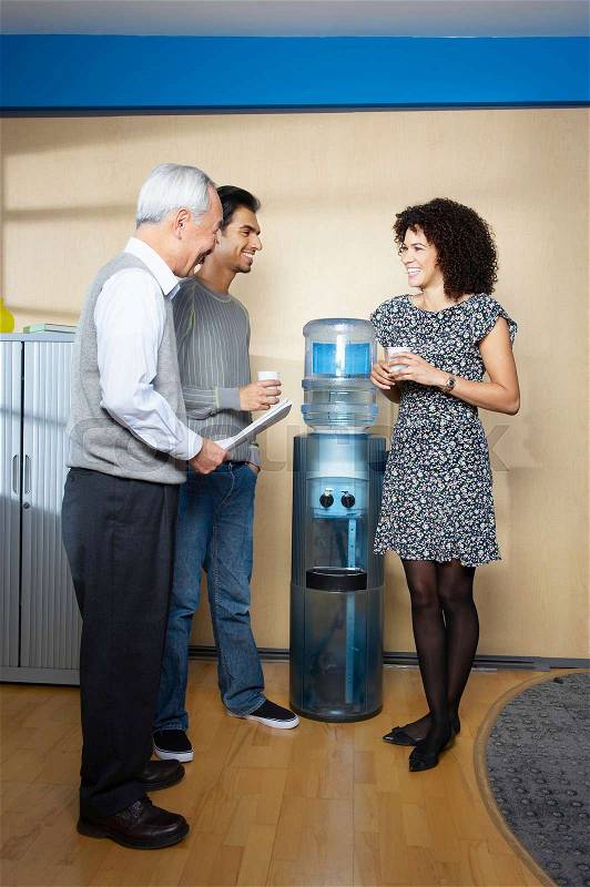 Casual meeting by office water cooler, stock photo