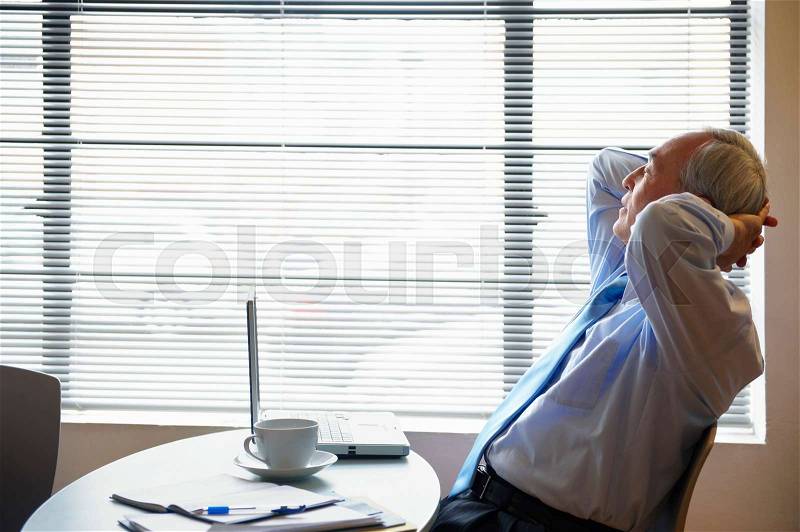Senior businessman relaxing in cafe, stock photo