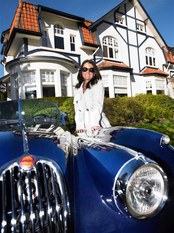 Woman in front of her house and car, stock photo
