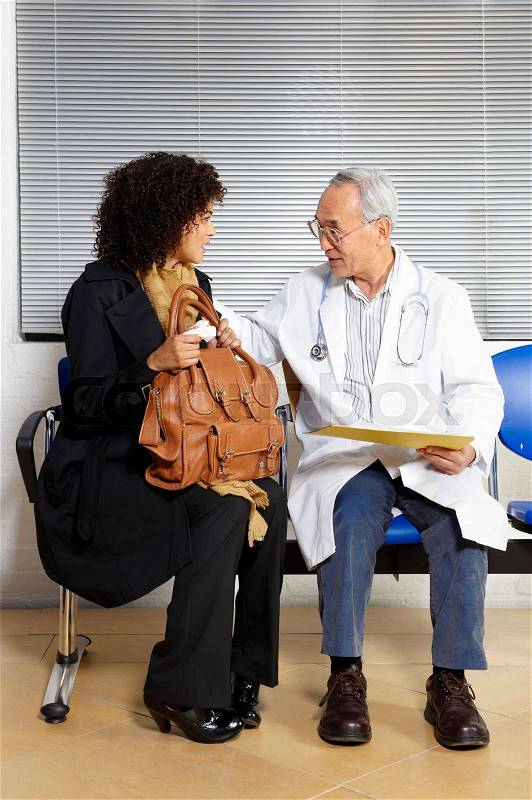 Young woman talking to doctor, stock photo
