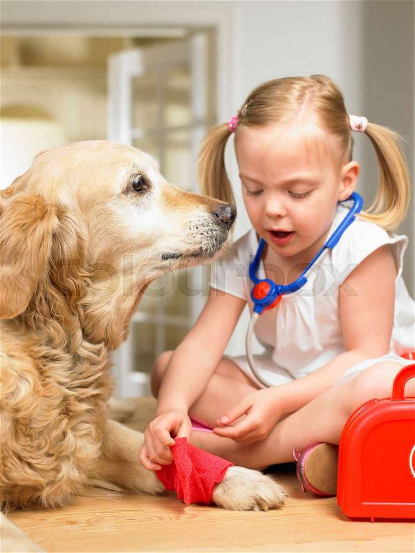 Girl playing doctor with dog, stock photo