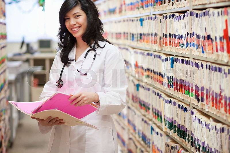 Female Doctor with medical file smiling, stock photo