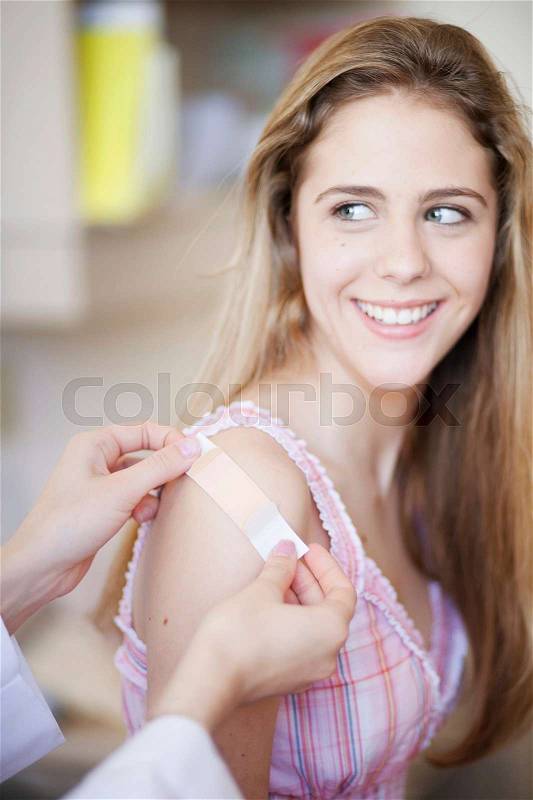 Plaster/bandage put on smiling girl, stock photo