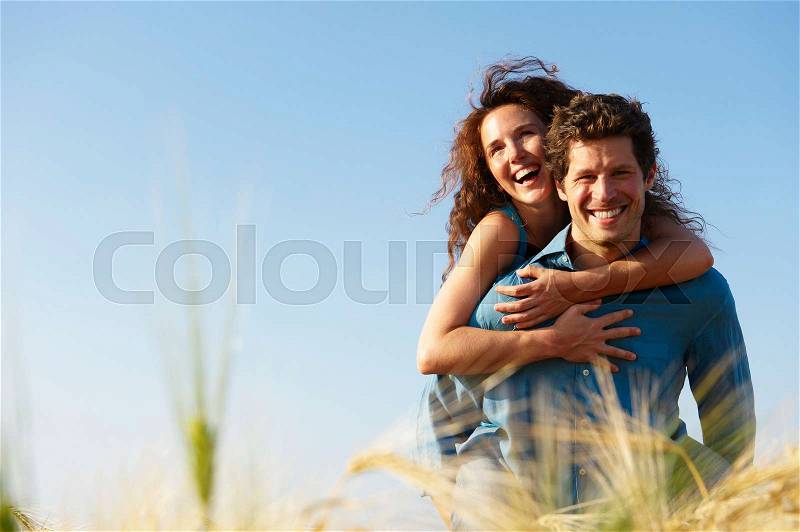 Man carrying woman in a wheat field, stock photo
