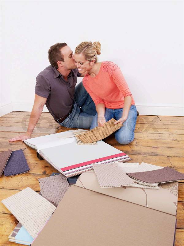 Couple looking at carpet samples, stock photo