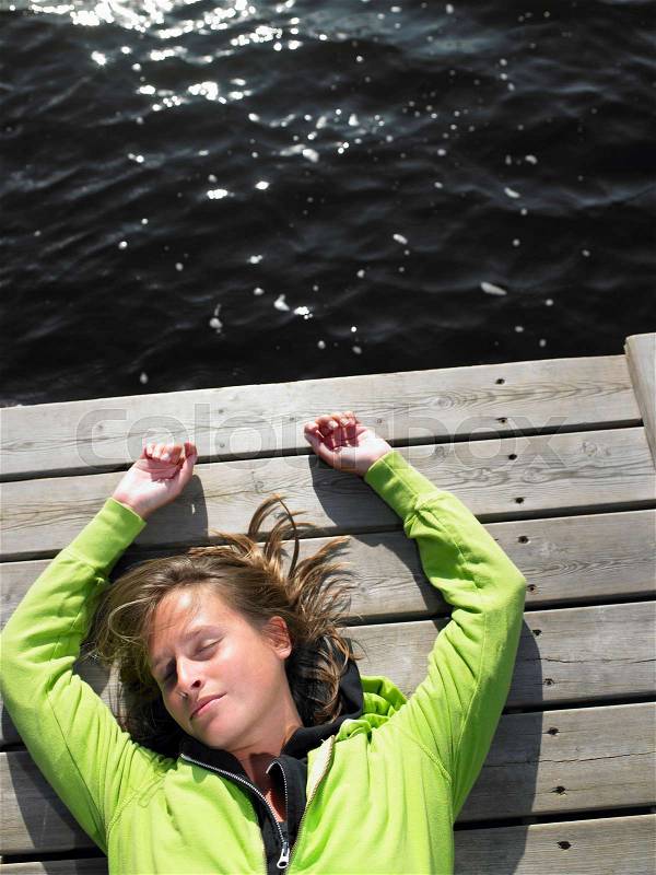 Woman laying down on a deck, stock photo