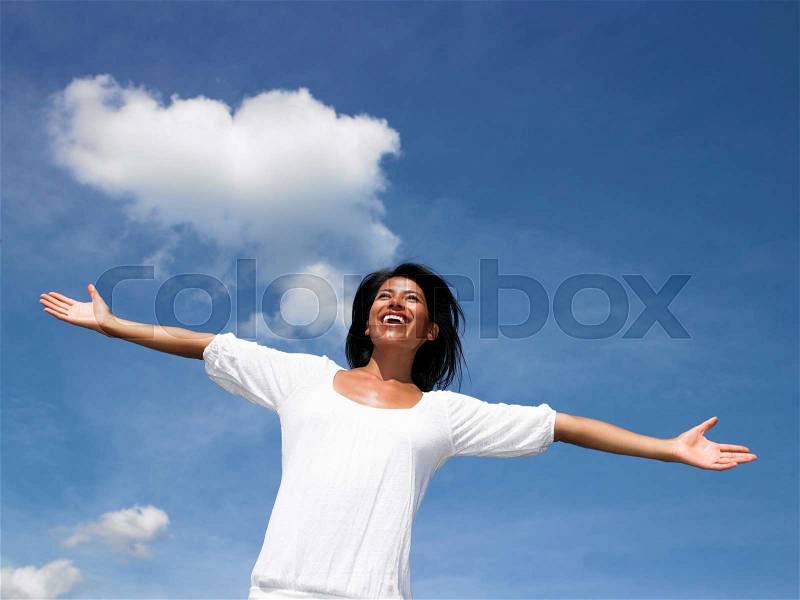 Woman spreading her arms towards the sky, stock photo