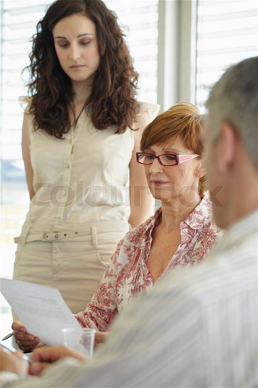 Older business woman reading document, stock photo