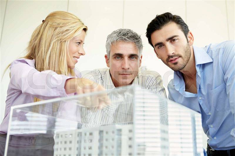 3 people looking at architectural model, stock photo